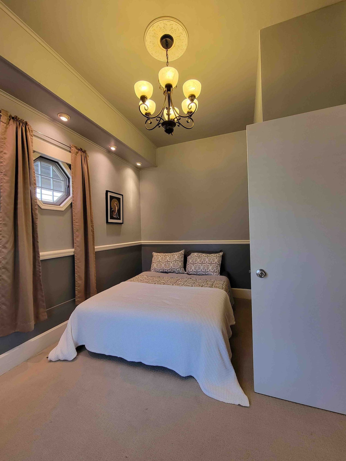 Bedroom with patterned pillows and white coverlet