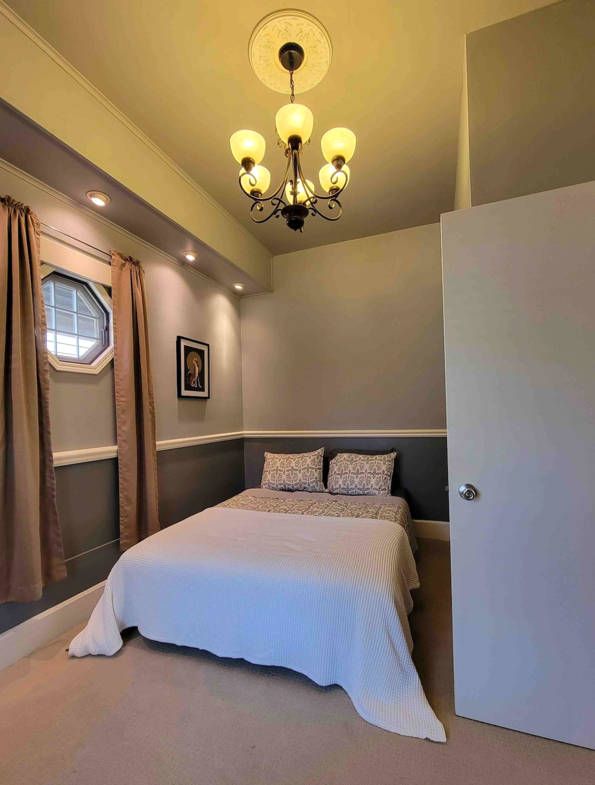 Second bedroom with artwork and chandelier